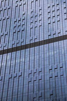 Close-up view of a modern glass facade skyscraper showcasing architectural design with reflective windows.