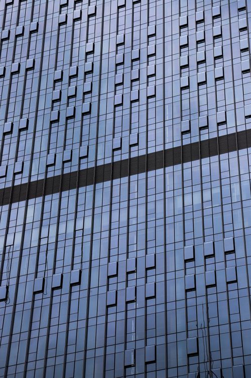 Free Close-up view of a modern glass facade skyscraper showcasing architectural design with reflective windows. Stock Photo
