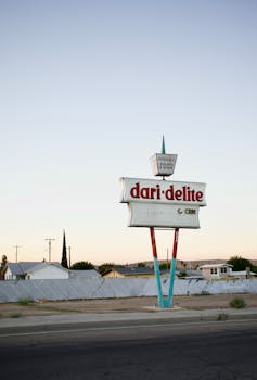 Classic Dari-Delite sign against a tranquil rural backdrop at twilight.