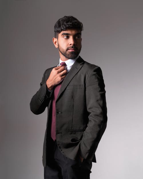 Man in Black Suit Jacket Holding Neck Tie