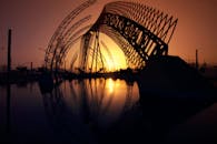 西班牙马拉加的现代建筑剪影倒映水中，捕捉了宁静的日落氛围