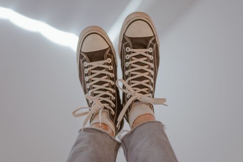 Free Pair of casual sneakers worn with jeans, suggesting a laid-back vibe. Stock Photo