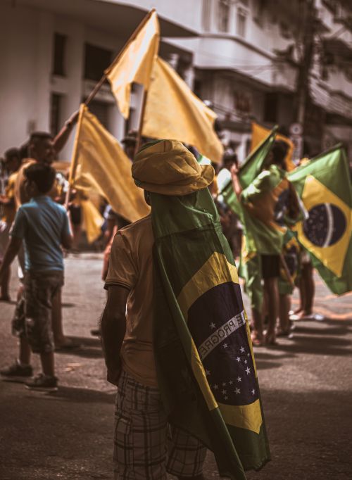Free A crowd of Brazilian protesters waving flags in a street demonstration. Stock Photo