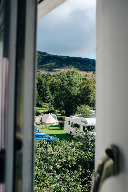 A Caravan and Vehicles on Green Grass