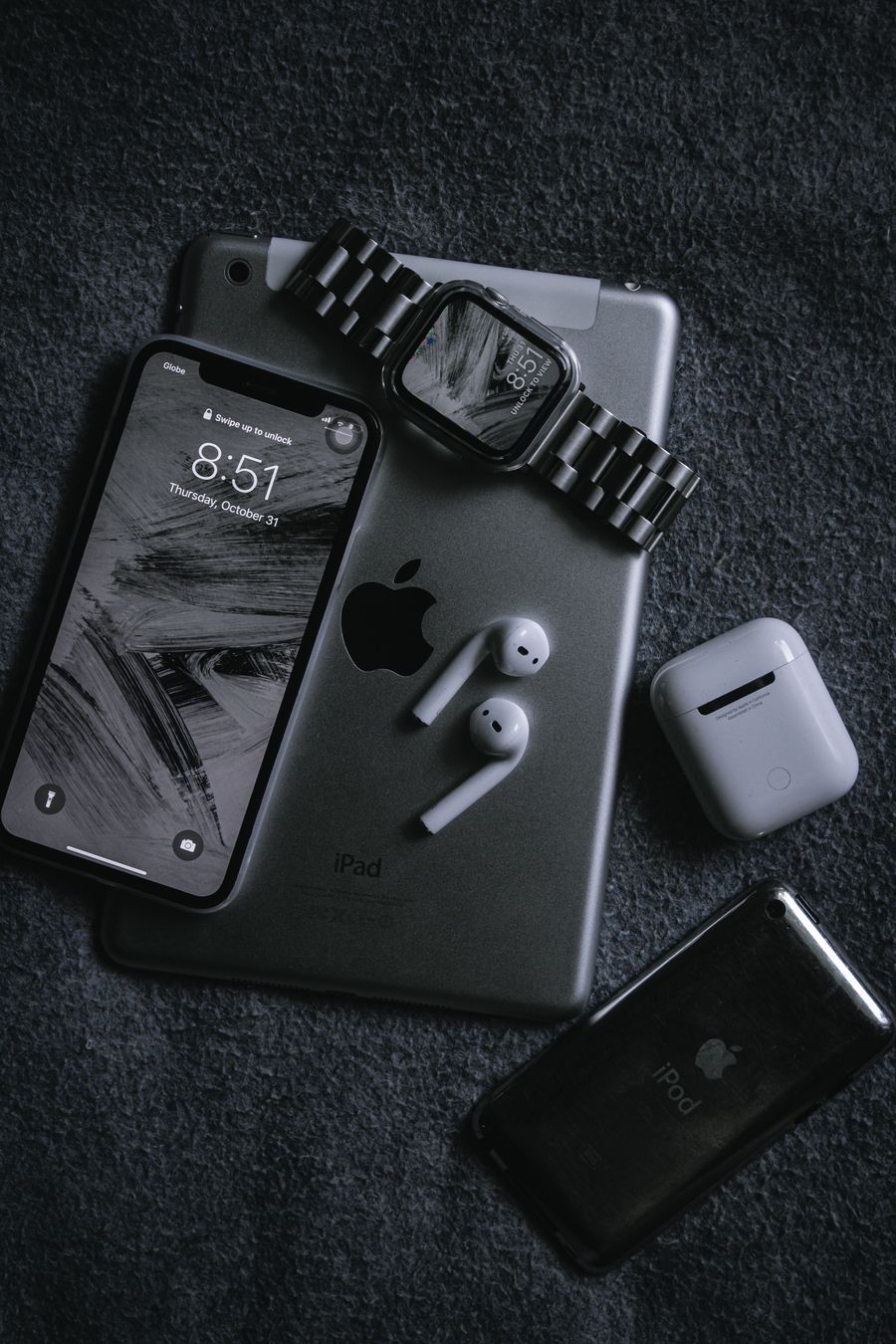 Smartwatch and wireless earbuds on a black surface