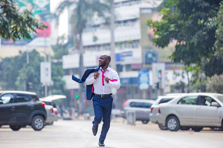 A Man In A Suit Running In The Street