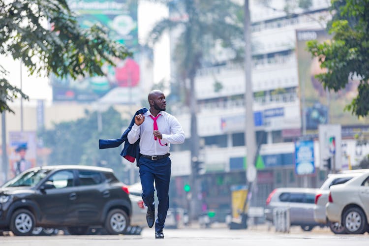 A Man In A Suit Running In The Street