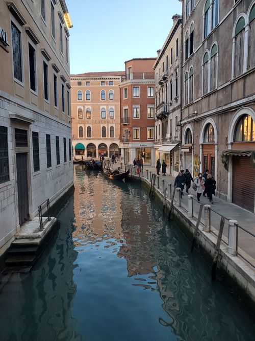 Free Scenic view of a canal in Venice with a gondola and historic architecture. Stock Photo
