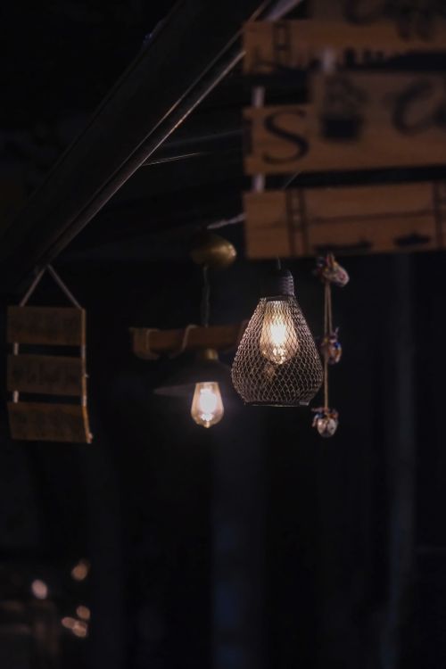 Free Warm lighting ambiance with industrial style hanging bulbs in dim setting. Stock Photo