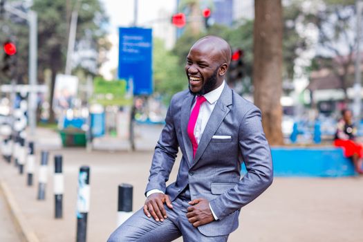 Man in Blue Suit Jacket and Gray Dress Pants Sitting on Concrete Bench