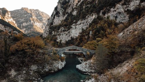 Free Stunning aerial view of a stone bridge nestled in autumnal mountain landscape in Greece. Stock Photo