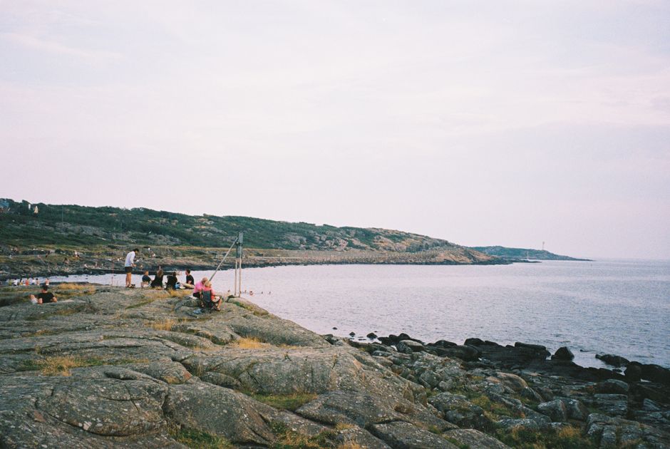 Scenic view of Varberg's rocky coastline in Sweden with people enjoying the outdoors.
