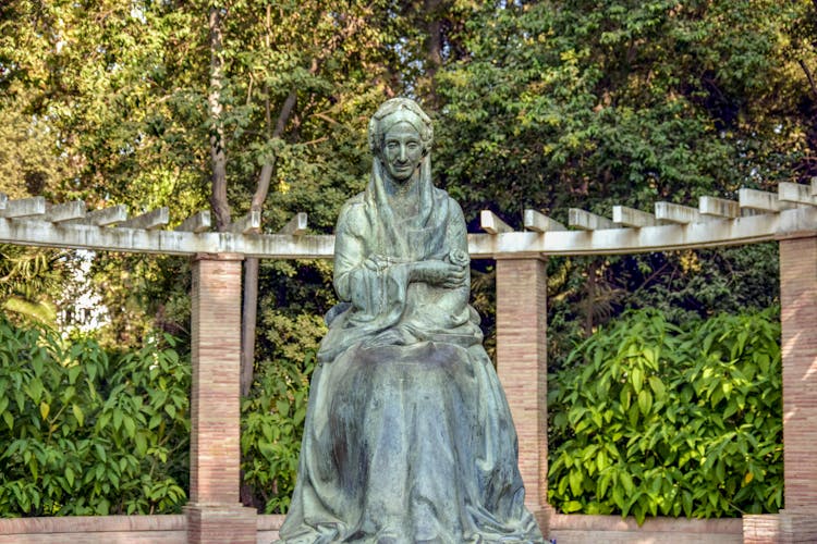 Statue Of Woman Near Green Trees