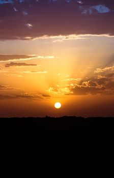 Captivating sunset in Timokten, Algeria, with vibrant clouds and golden hues. Perfect for serene landscape lovers.