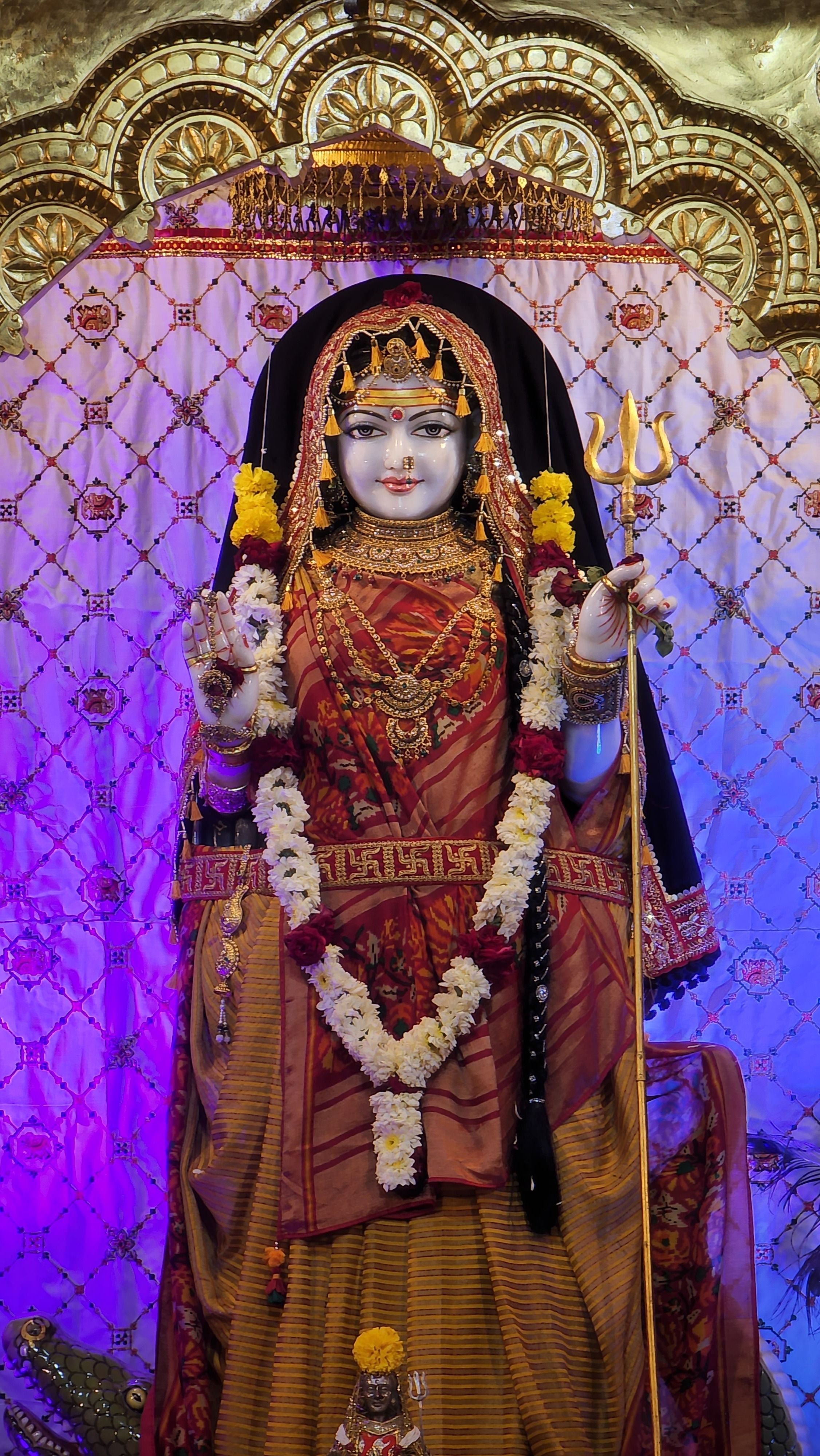 Beautifully ornate statue of an Indian goddess adorned with garlands, showcasing traditional attire and spiritual symbolism.