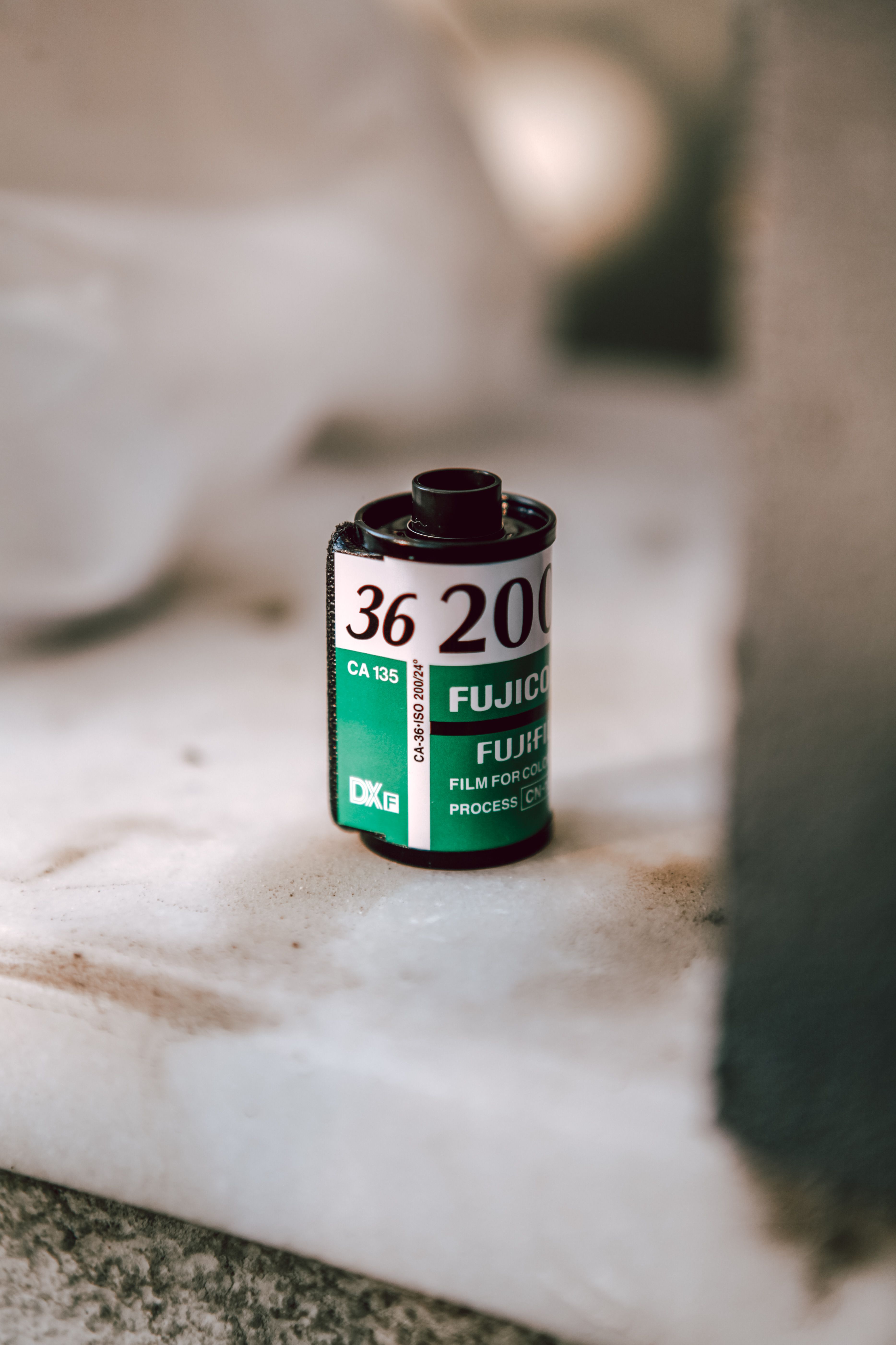 Vintage Fujifilm 200 ISO film roll on a marble surface, evoking nostalgia and retro vibes.
