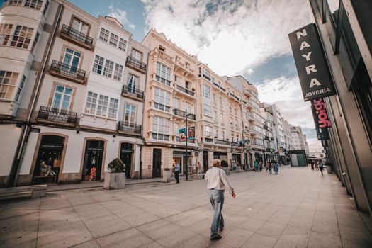 Scenic view of a bustling European street lined with historic architecture and pedestrians on a sunny day.