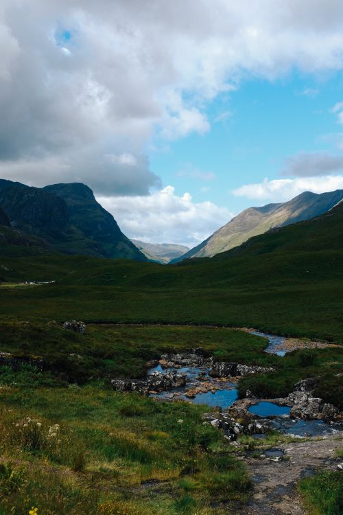 Free Explore the breathtaking mountain valley with rugged terrain and dramatic cloud formations. Stock Photo