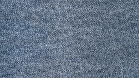 Detailed close-up of a textured blue fabric surface, perfect for backgrounds.