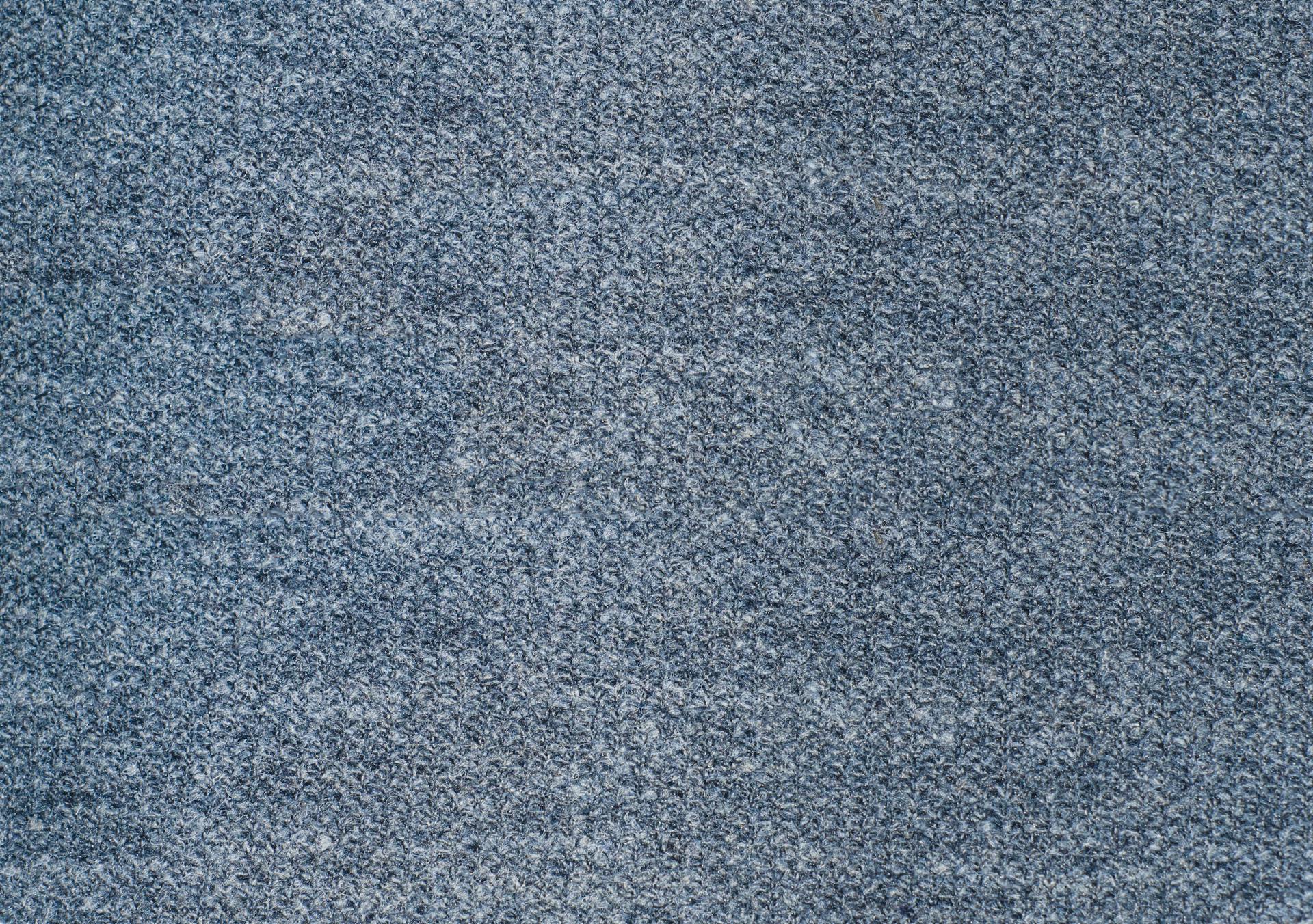 Detailed close-up of a textured blue fabric surface, perfect for backgrounds.