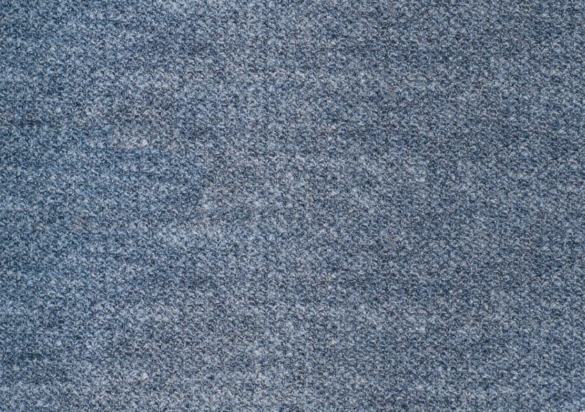 Close-up of a soft blue cloth in which blue and white yarns cross in a plain weave, giving a finely mixed blue face.