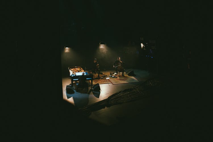 Men Playing Musical Instruments In Dark Studio