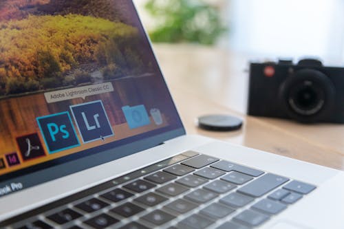 Free Selective Focus Photography of Macbook Pro Near Film Camera Stock Photo