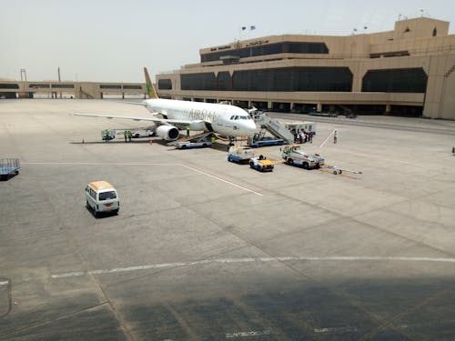 White Airplane on Tarmac Near an Airport Building