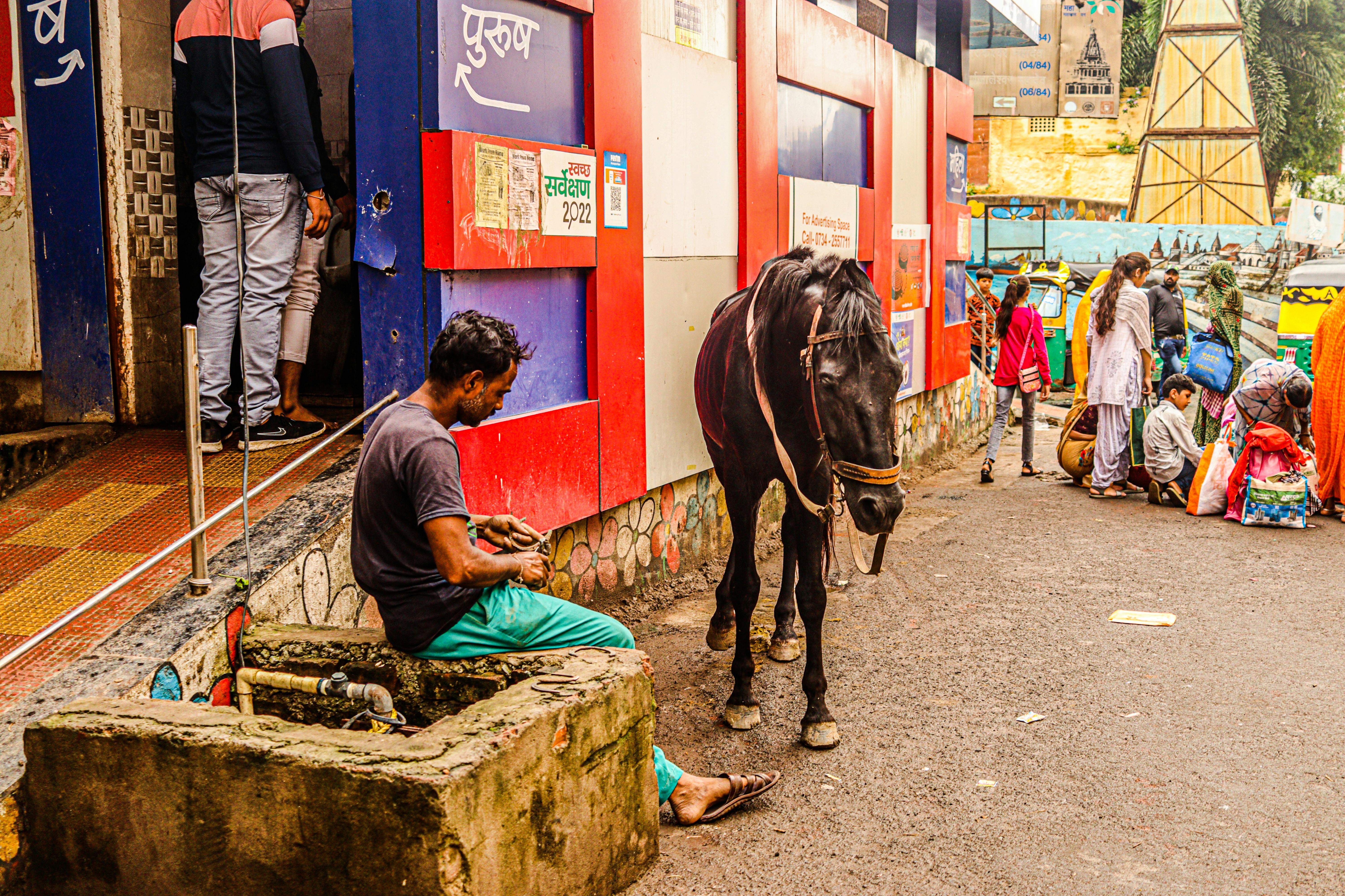 An urban street scene featuring people and a horse, capturing daily life in the city.