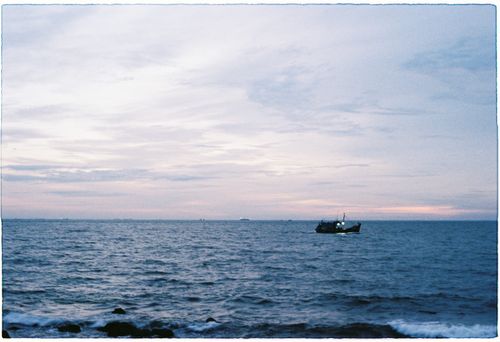 Free A serene fishing boat on the sea at dusk in Vũng Tàu, capturing a peaceful skyscape. Stock Photo