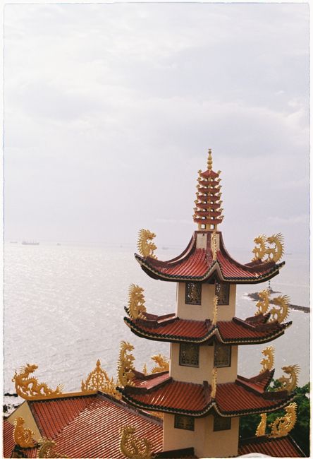 A stunning traditional Asian pagoda with intricate roof designs overlooking the water.
