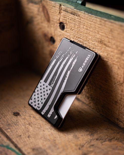 Free Close-up of a sleek metal wallet featuring an American flag design on a wooden surface. Stock Photo