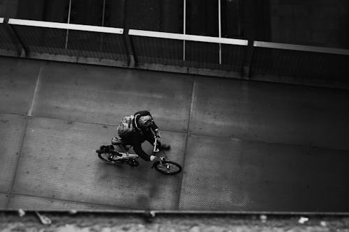 Free Grayscale Photo of Person Pushing his Bike Stock Photo