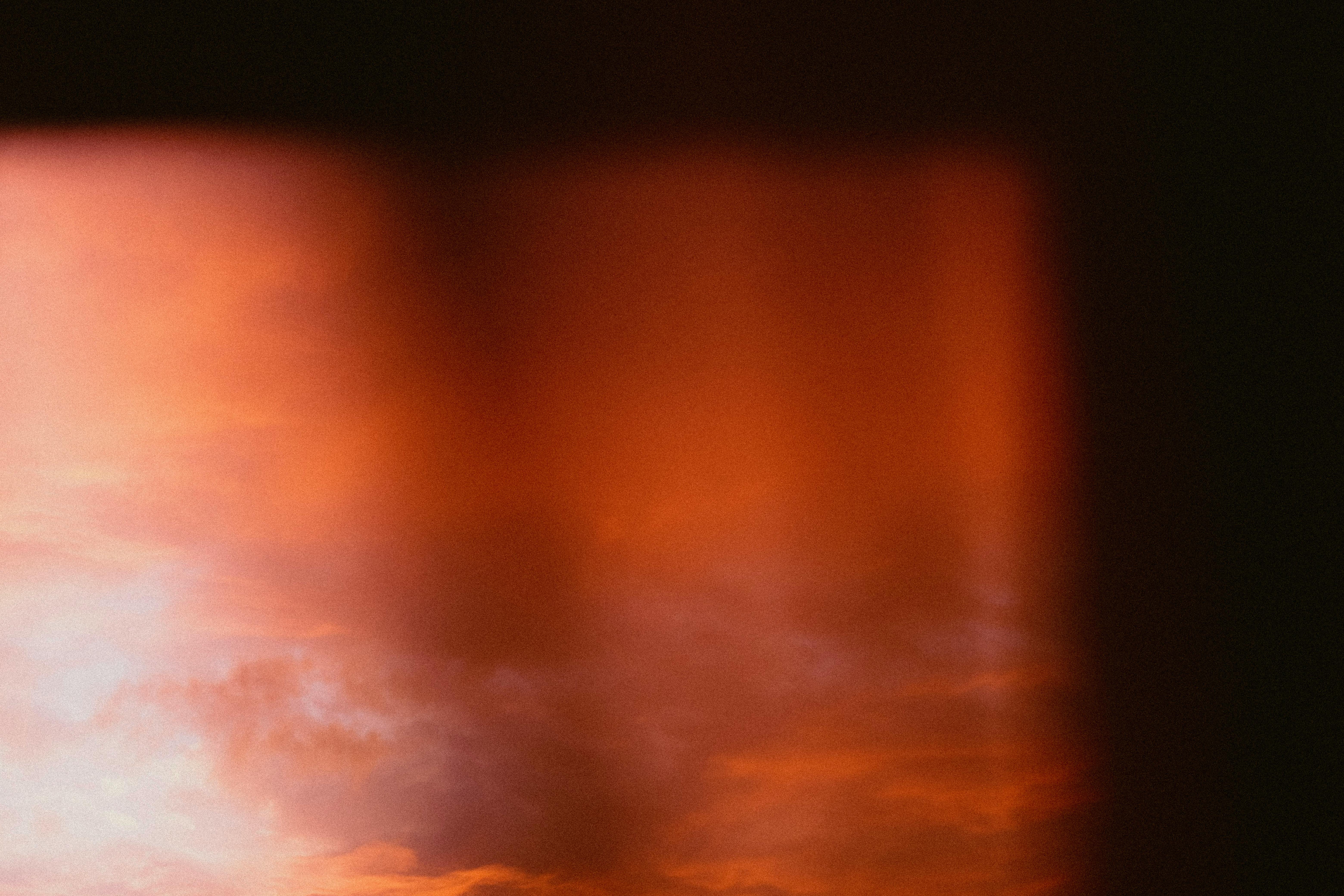 Atmospheric blurred sunset sky with rich orange tones, creating a dramatic and dreamy effect.
