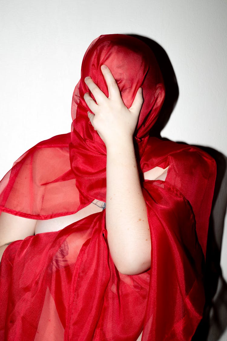 Person Covering Face With A Red Cloth