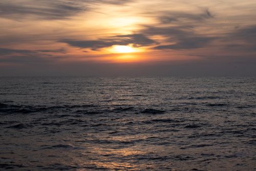 Free Beautiful sunset over the ocean with vibrant colors and peaceful waves. Stock Photo