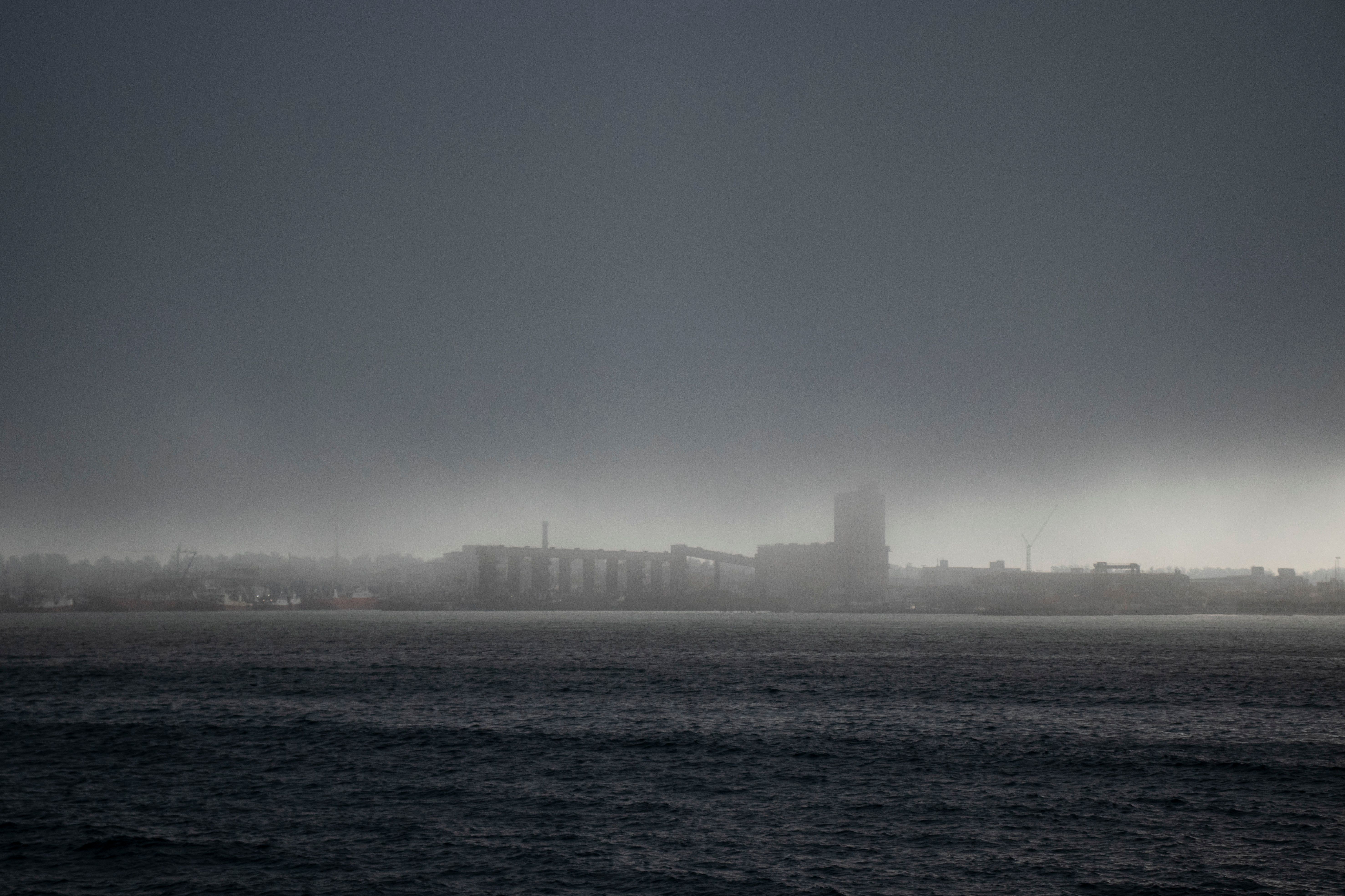 Silhouette of Buildings Across the Ocean · Free Stock Photo