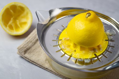 Free Close-up of a lemon being juiced on a metal citrus juicer, emphasizing freshness and health. Stock Photo