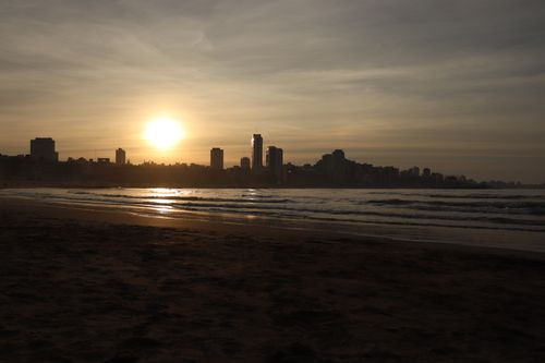 Free Captivating beach sunset with Mar del Plata skyline silhouetted against the horizon. Stock Photo