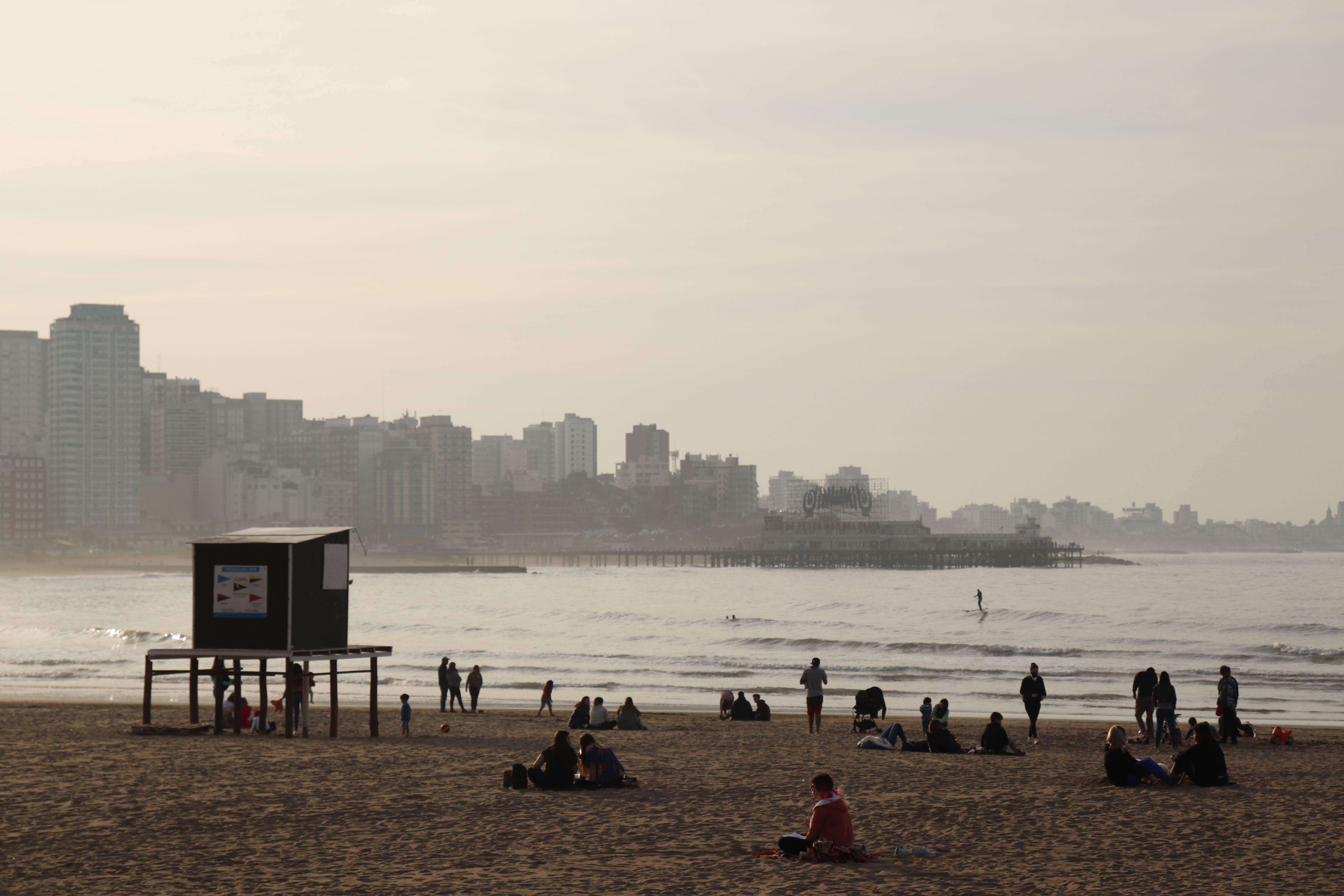 Sunny day at Mar del Plata beach with tourists enjoying the seashore and city skyline.