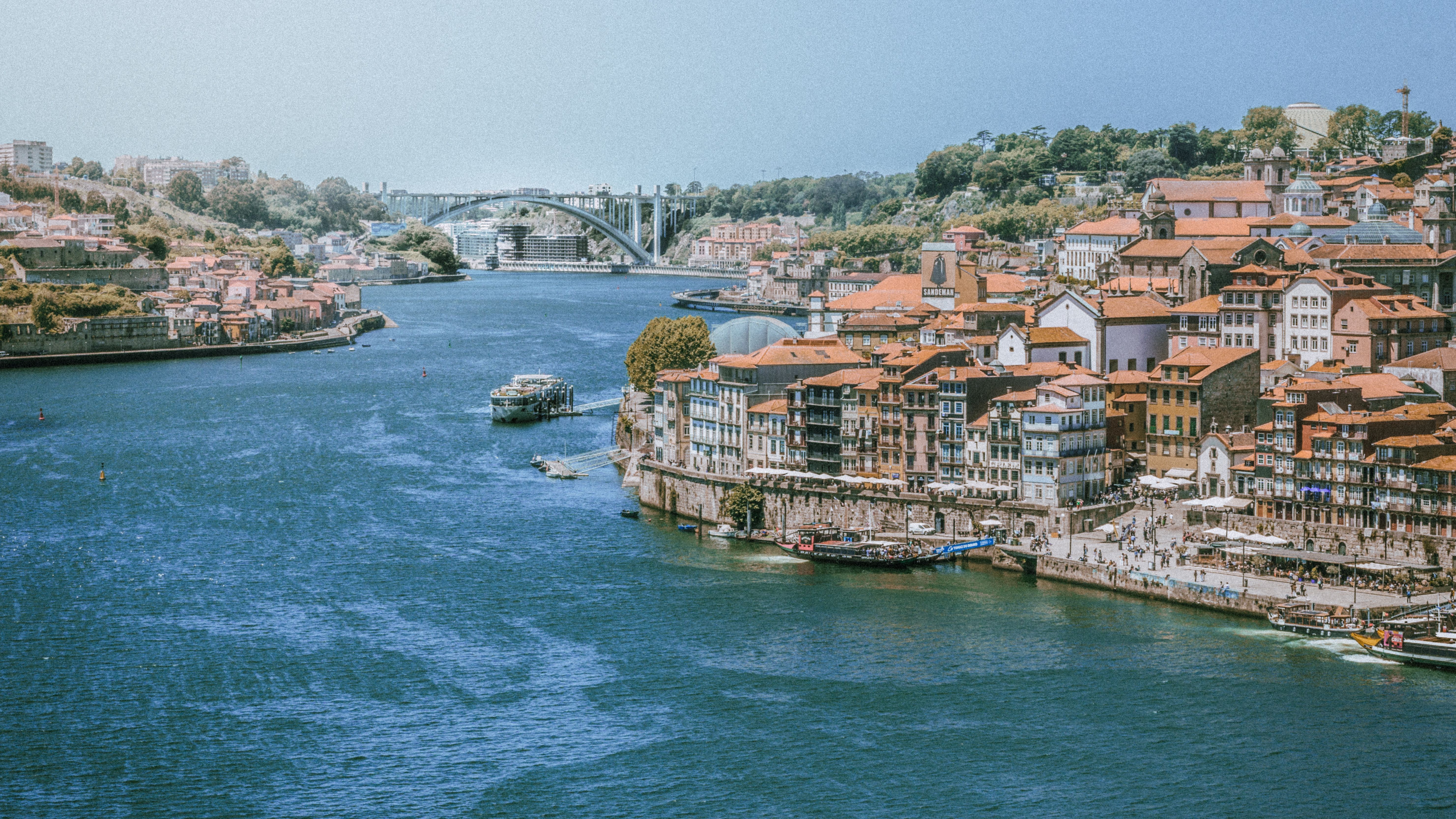 Panoramic view of Vila Nova de Gaia's riverside with charming architecture and bridge.