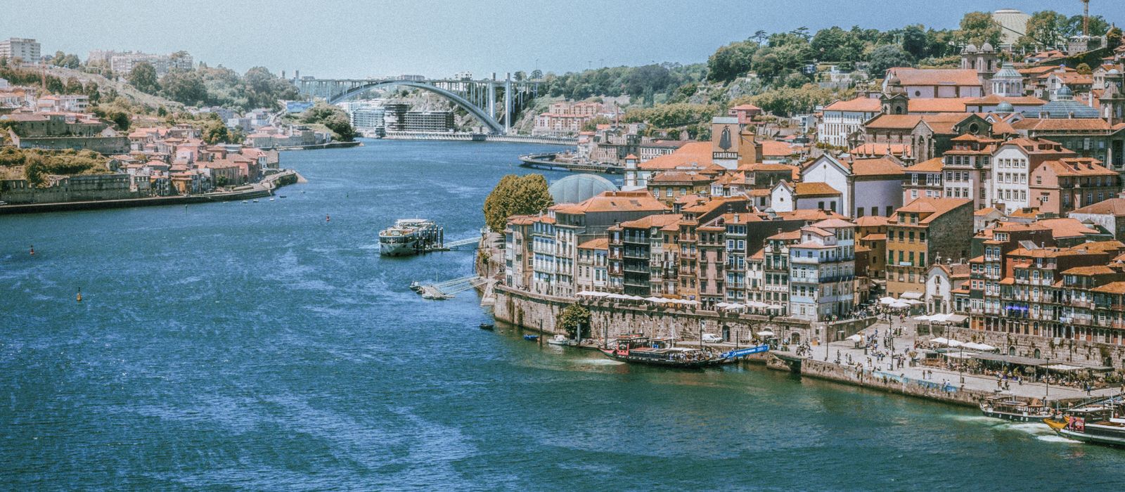 Panoramic view of Vila Nova de Gaia's riverside with charming architecture and bridge.