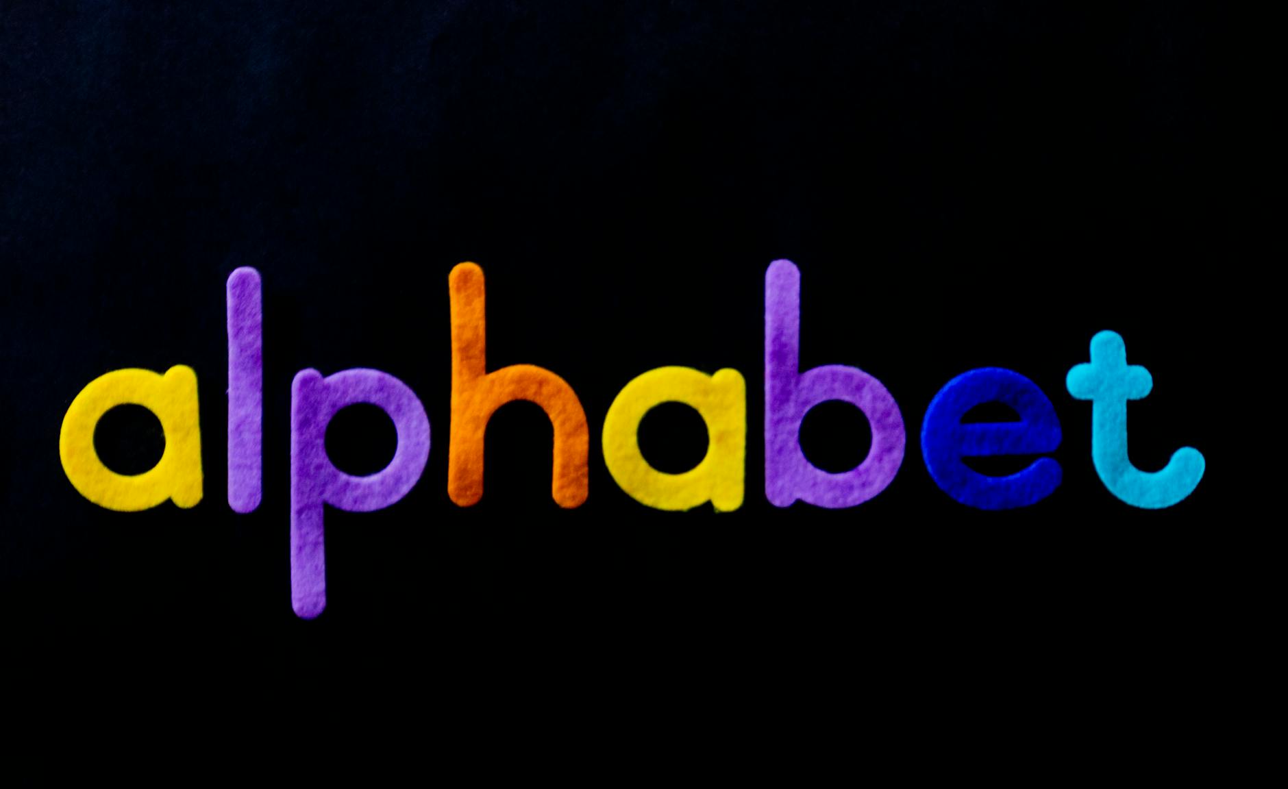 Vivid colorful alphabet letters on a black background showcasing creativity and design.
