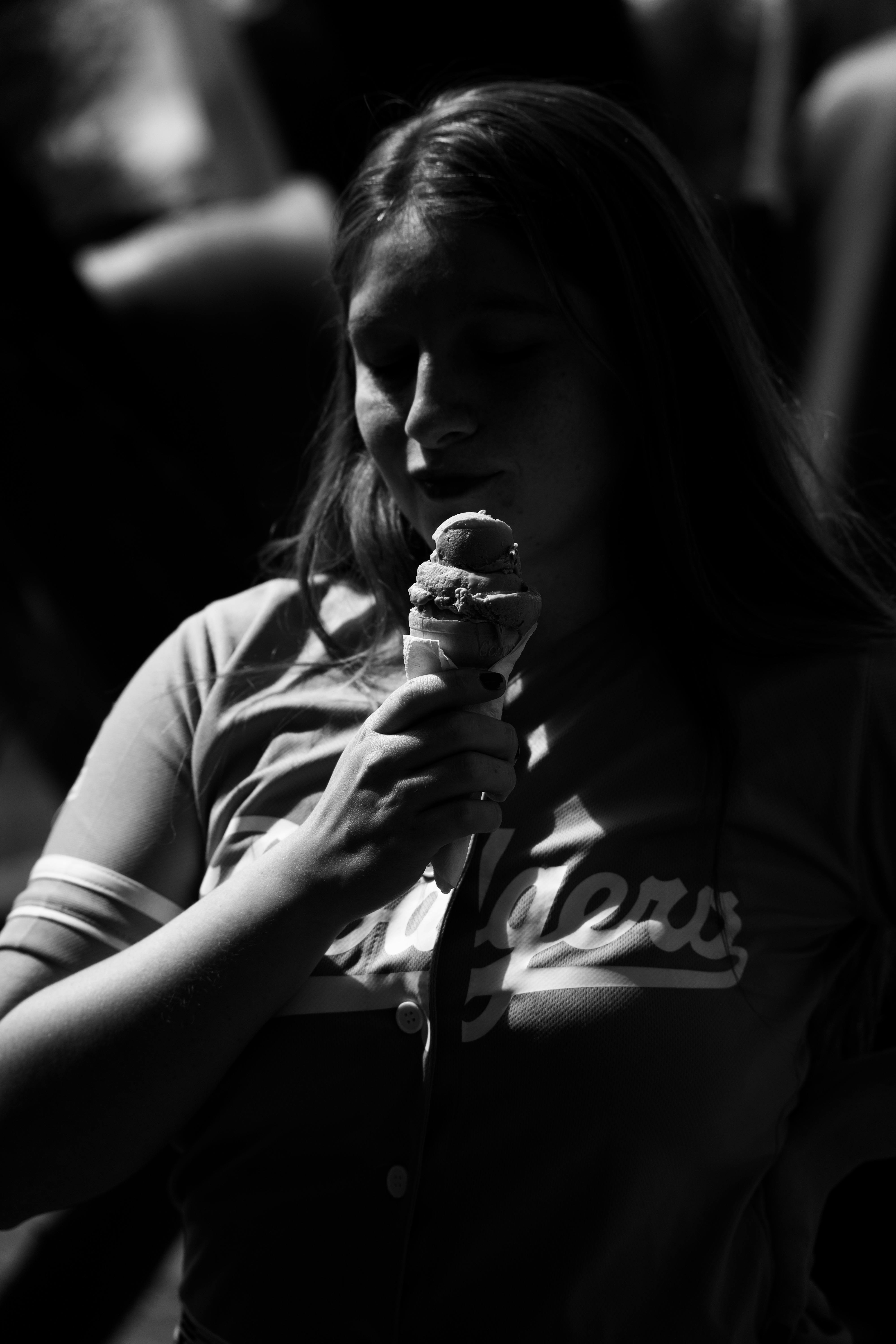 grayscale photo of a teenage girl eating ice cream