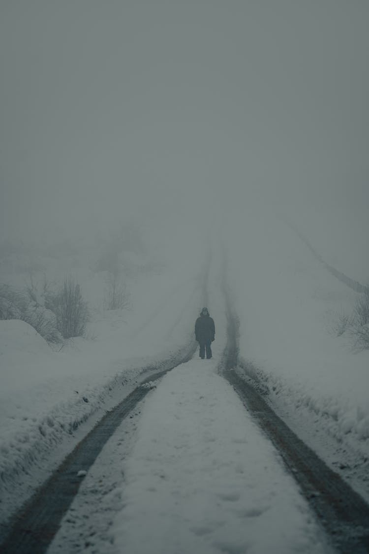 Man Standing In The Middle Of The Road On A Winter Foggy Day