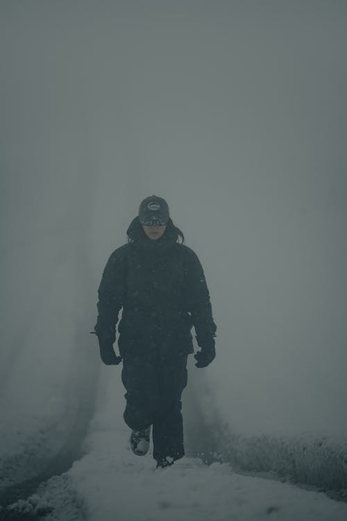 Woman Walking on a Snow Covered Road