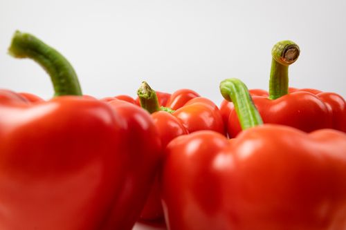 Free Close-up view of fresh red bell peppers showcasing their bright color and juicy texture. Stock Photo