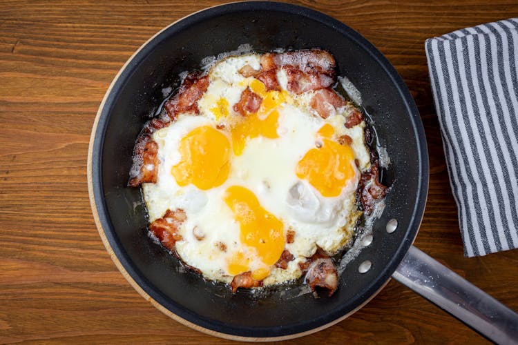 A Frying Pan With Bacon And Eggs