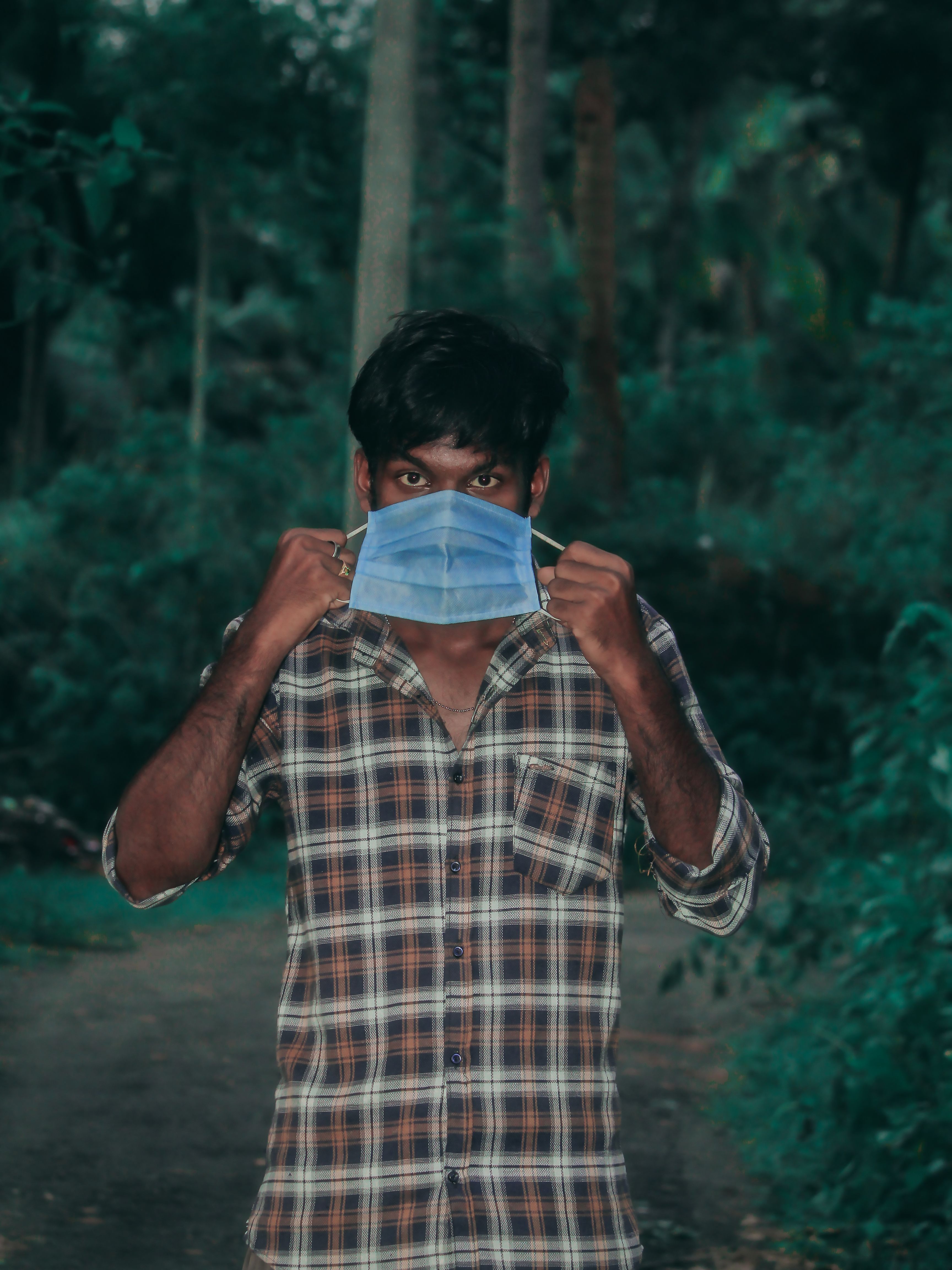Man in Plaid Shirt Holding a Medical Face Mask · Free Stock Photo