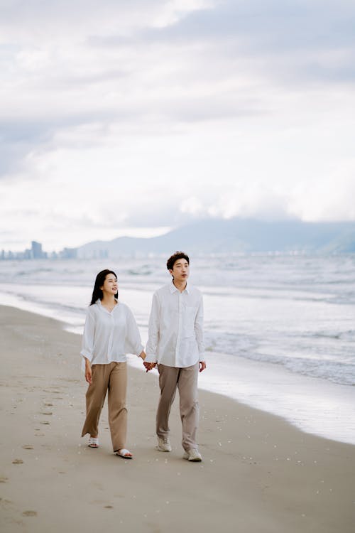 Pria Dan Wanita Berjalan Bersama Di Sepanjang Pantai Berpasir
